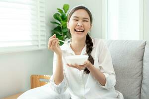 gesund Lebensmittel. schön weiblich Mädchen genießen Essen Joghurt, Granola, frisch Früchte auf Frühstück Gesundheit im Haus. glücklich jung Frau Lächeln auf Morgen gut Emotion. Diät, Entgiftung, Diät, sauber essen, Vegetarier foto