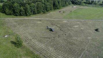 Hubschrauber ist eingetroffen auf Grün Feld. Hubschrauber gelandet auf Gelb Gras, wolkig Tag. fliegend Drohne und Grün Weizen Feld foto