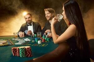 Gruppe von jung Reich Menschen ist spielen Poker im das Kasino foto