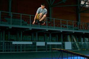 Rollerblader springen hoch von groß Luft Rampe durchführen Trick. drinnen Schlittschuh Park Ausrüstung. foto