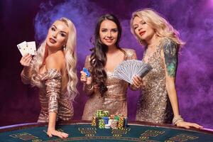 schön Mädchen mit ein perfekt Frisuren und hell bilden sind posieren Stehen beim ein Glücksspiel Tisch. Kasino, Poker. foto