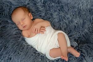 Neugeborene Baby Junge im Bett. Neu geboren Kind Schlafen unter ein Weiß gestrickt Decke. Kinder schlafen. foto