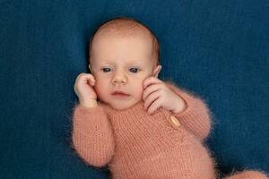 Neugeborene Baby Junge 14 Tage tragen gestrickt passen Schlafen im Bett Nahansicht. foto