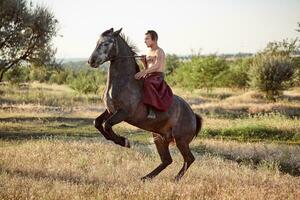 gut aussehend Mann Cowboy Reiten auf ein Pferd - - Hintergrund von Himmel und Bäume foto