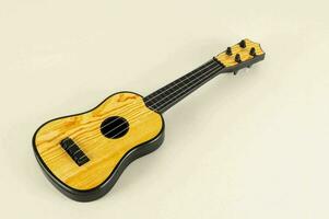 ein klein Ukulele auf ein Weiß Hintergrund foto