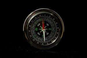 ein Kompass auf ein schwarz Hintergrund foto