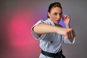 sportlich Frau im traditionell Kimono ist üben Karate im Studio. foto