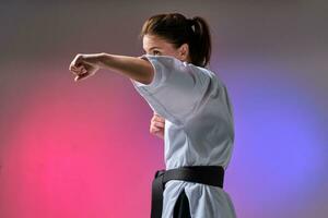 sportlich Frau im traditionell Kimono ist üben Karate im Studio. foto