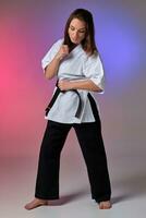 sportlich Frau im traditionell Kimono ist üben Karate im Studio. foto