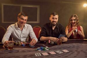 Gruppe von ein jung reich freunde sind spielen Poker beim ein Kasino. foto