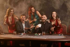 Gruppe von ein jung reich freunde sind spielen Poker beim ein Kasino. foto