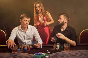 Gruppe von ein jung reich freunde sind spielen Poker beim ein Kasino. foto