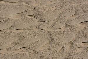 ein schließen oben von Sand mit wellig Muster foto