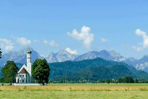 ein Kirche im das Mitte von ein Feld mit Berge im das Hintergrund foto