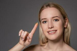 jung Frau halten Kontakt Linse auf Index Finger mit Kopieren Raum. schließen oben Gesicht von gesund schön Frau Über zu tragen Kontakt Linse. foto