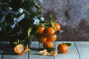 Mandarinen im ein Gittergewebe Eimer auf ein Tabelle , ein Hintergrund Neu Jahre Stimmung foto