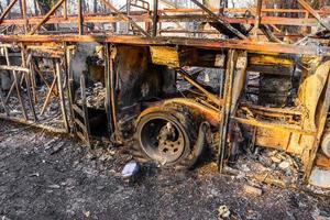 verbrannter Bus wird auf der Straße gesehen, nachdem er während der Fahrt in Brand geraten war, nach dem Brand foto