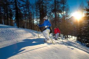 Ausflug mit Schneeschuhen von zwei Frauen bei Sonnenuntergang, Stock-Foto foto