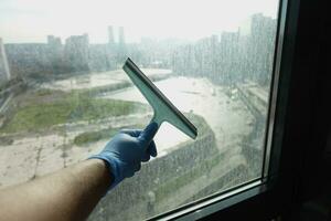 Nahaufnahme der Hand des Mannes, die Fensterglas putzt foto