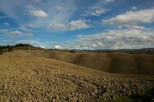 berühmt Toskana Landschaft mit gebogen Straße und Zypresse, Italien, Europa. ländlich Bauernhof, Zypresse Bäume, Grün Feld, Sonnenlicht und Wolke. foto