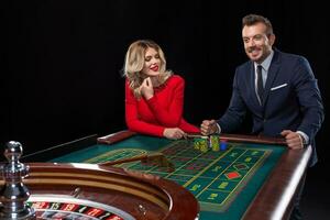 schön und Gut gekleidet Paar spielen Roulette im das Kasino foto