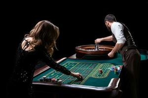 Croupier und Frau Spieler beim ein Tabelle im ein Kasino. Bild von ein c foto