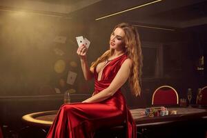 jung schön Frau ist posieren gegen ein Poker Tabelle im Luxus Kasino. foto
