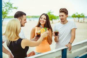 freunde haben Spaß beim das Bar draußen, Trinken Cocktails. foto