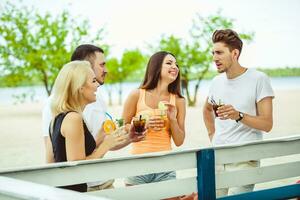 freunde haben Spaß beim das Bar draußen, Trinken Cocktails. foto