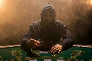 Porträt von ein Fachmann Poker Spieler Sitzung beim Schürhaken Tabelle foto