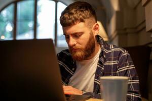 jung Fachmann Surfen das Internet auf seine Laptop im ein Cafe foto