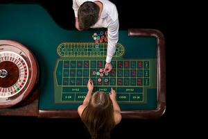 Mann Croupier und Frau spielen Roulette beim das Tabelle im das Kasino. oben Aussicht beim ein Roulette Grün Tabelle mit ein Band messen. foto