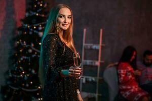 schön jung Frau mit Glas von Champagner beim Weihnachten Party foto