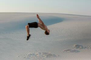 Mann Studie Parkour auf ihr eigen. Akrobatik im das Sand foto