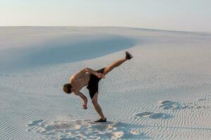 Mann Studie Parkour auf ihr eigen. Akrobatik im das Sand foto