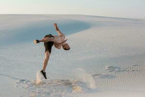 Mann Studie Parkour auf ihr eigen. Akrobatik im das Sand foto