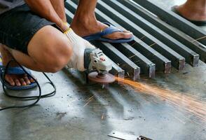 Arbeiter Schneiden Metall mit Schleifer mit Funken foto