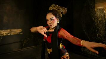ein indonesisch Tänzer sucht aus und lädt ein das Publikum zu Sein getragen Weg im ein kulturell Performance foto