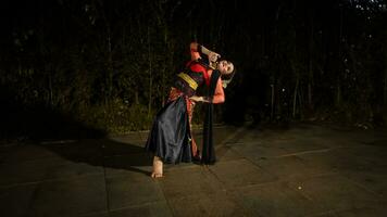 ein javanisch Tänzer im ein rot Kostüm vorgestellt ein tanzen Das gefesselt das Publikum mit seine Fertigkeit foto