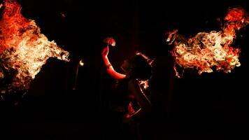 das Silhouette von ein weiblich Tänzer halten Schmuck scheint hell um das Flammen und sieht aus Fett gedruckt im das dunkel foto