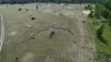 Hubschrauber ist eingetroffen auf Grün Feld. Hubschrauber gelandet auf Gelb Gras, wolkig Tag. fliegend Drohne und Grün Weizen Feld foto