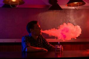 das Mann Rauch ein elektronisch Zigarette beim das Dampfen Geschäft. foto