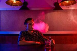 das Mann Rauch ein elektronisch Zigarette beim das Dampfen Geschäft. foto