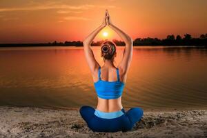 Yoga beim Sonnenuntergang auf das Strand. foto