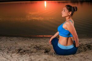 Yoga beim Sonnenuntergang auf das Strand. foto