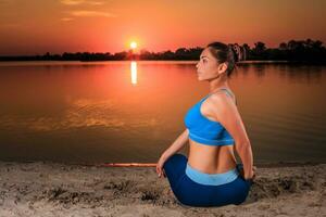 Yoga beim Sonnenuntergang auf das Strand. foto