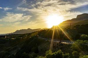 Landschaft mit den Sonnenstrahlen über der Straße foto