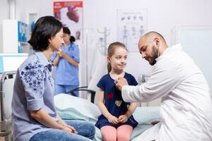 Arzt Pädiatrie geben Kind Untersuchung im medizinisch Büro mit Stethoskop während medizinisch Termin. Arzt Spezialist im Medizin Bereitstellung Fachmann Gesundheitswesen Behandlung Dienstleistungen foto