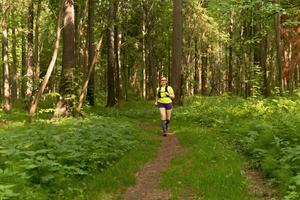 jung Frau Joggen auf ein Pfad im ein natürlich Wald Park foto