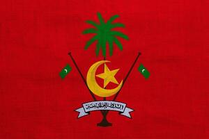 Flagge und Mantel von Waffen von Republik von Malediven auf ein texturiert Hintergrund. Konzept Collage. foto